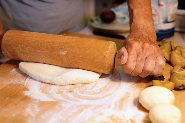 Preparazione di gnocchi di frutta fatti in casa con prugne specialità ceca di dolce buon cibo pasta sul tavolo di legno della cucina con le mani