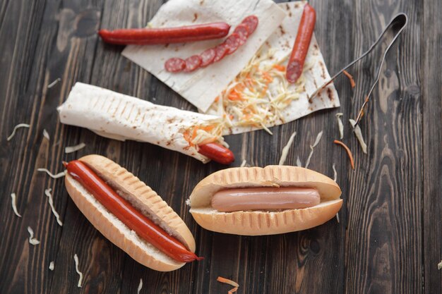 Preparazione di hot dog con salsicciafoto su fondo di legno