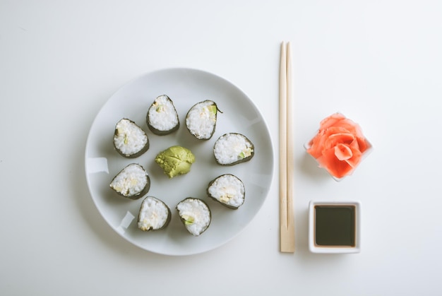 Preparazione di involtini di sushi vegetariani di avocado e cetriolo con wasabi allo zenzero e salsa di soia