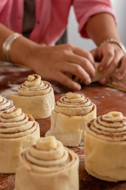 Preparazione di rotoli di cannella Primo piano delle mani di un Woman039s che fanno allungare i rotoli di cannella