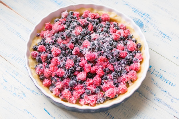 Preparazione di una crostata con frutti di bosco freschilampone e ribes nero