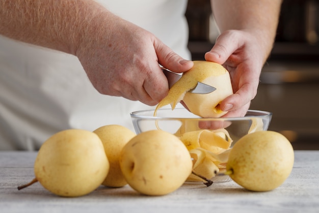 Preparazione di una macedonia di frutta fresca con carote, pere e mele