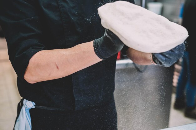 Preparazione di una pizza fatta in casa in stile italiano da parte di uno specialista