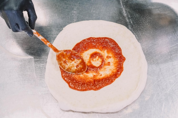 Preparazione di una pizza fatta in casa in stile italiano da parte di uno specialista