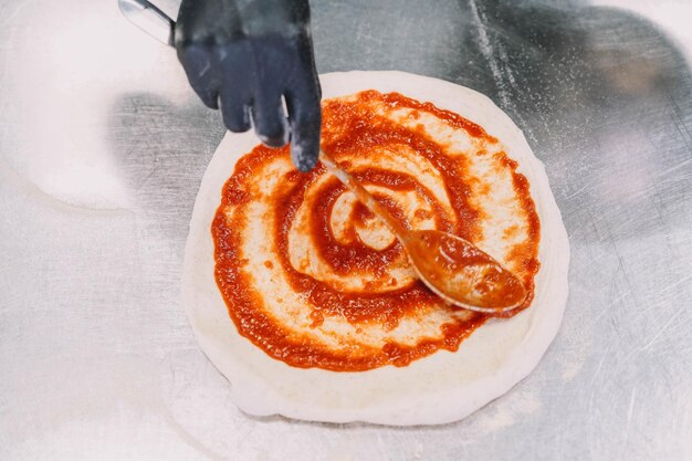 Preparazione di una pizza fatta in casa in stile italiano da parte di uno specialista