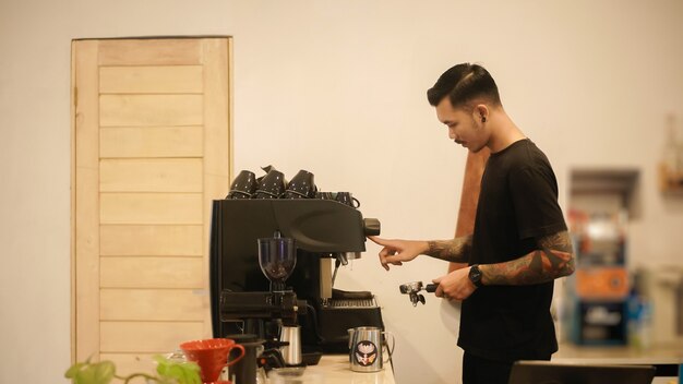 preparazione per fare il caffè da un barista maschio utilizzando una macchina in una caffetteria