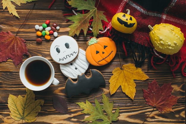 Preparazione per Halloween: Decorazione autunnale, zucche, plaid, foglie, panpepato, caramelle e caffè.