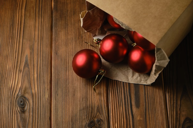 Preparazione per il Natale. Decorazioni per l'albero di Natale. Palle di natale rosse in una scatola su un tavolo di legno