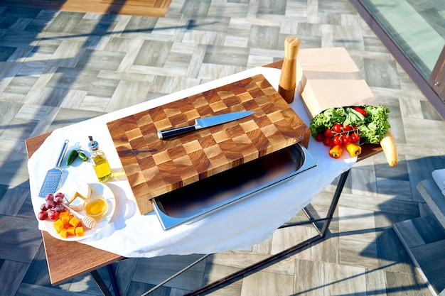 Preparazione per la cena sulla terrazza estiva. Immagine di un pannello divisorio con prodotti.