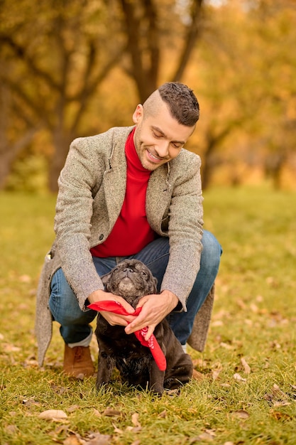 Preparazione per la passeggiata. Un proprietario di animali che mette il collare al suo cane