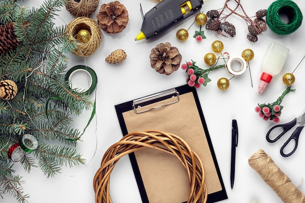 Preparazione per le vacanze di natale o capodanno flatlay di pelliccia rami di alberi ghirlande corda forbici artigianali...