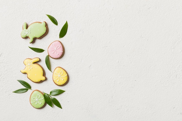 Preparazione per le vacanze Uova di Pasqua multicolori con biscotti su sfondo colorato Concetto di vacanza delle uova di Pasqua di colore pastello con spazio per la copia