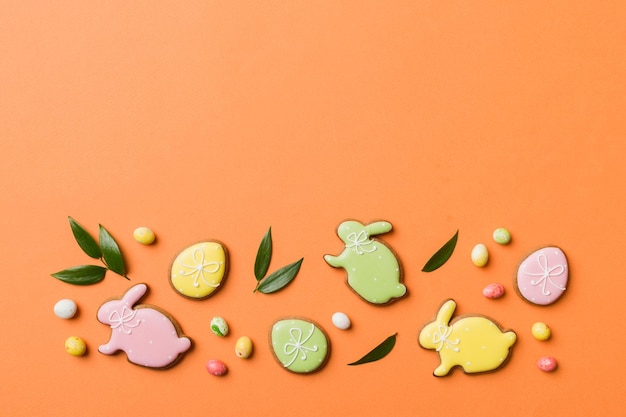 Preparazione per le vacanze Uova di Pasqua multicolori con biscotti su sfondo colorato Concetto di vacanza delle uova di Pasqua di colore pastello con spazio per la copia