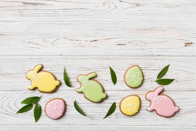 Preparazione per le vacanze Uova di Pasqua multicolori con biscotti su sfondo colorato Concetto di vacanza delle uova di Pasqua di colore pastello con spazio per la copia