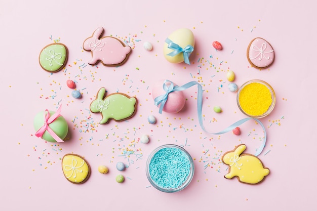 Preparazione per le vacanze Uova di Pasqua multicolori con biscotti su sfondo colorato Concetto di vacanza delle uova di Pasqua di colore pastello con spazio per la copia