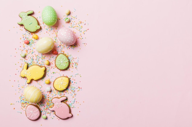 Preparazione per le vacanze Uova di Pasqua multicolori con biscotti su sfondo colorato Concetto di vacanza delle uova di Pasqua di colore pastello con spazio per la copia