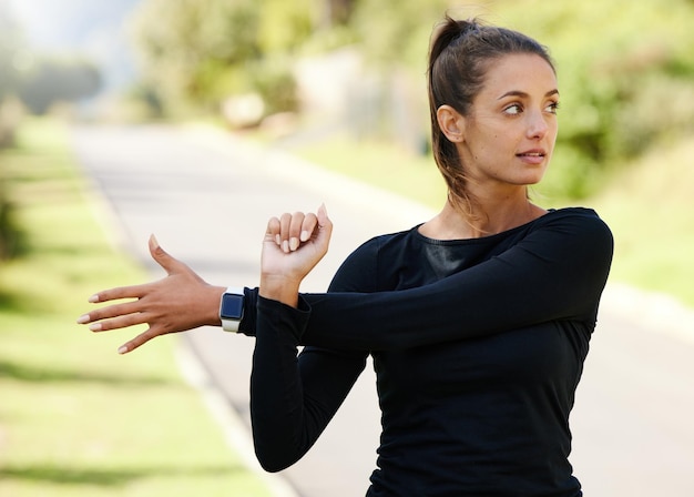 Preparazione per un allenamento Foto ritagliata di una giovane donna attraente e atletica che si riscalda prima di iniziare la sua corsa all'aperto