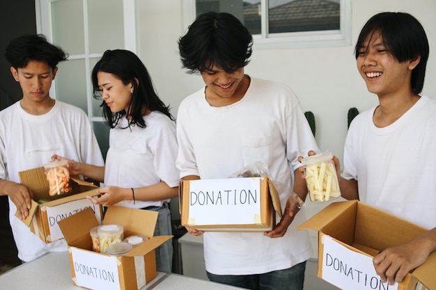 Preparazione per un evento di beneficenza Attivista umanitario che impaccha cibo per la donazione