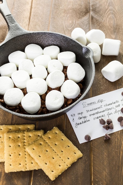 Preparazione smores tuffo preparato con grandi marshmallow in padella di ghisa.