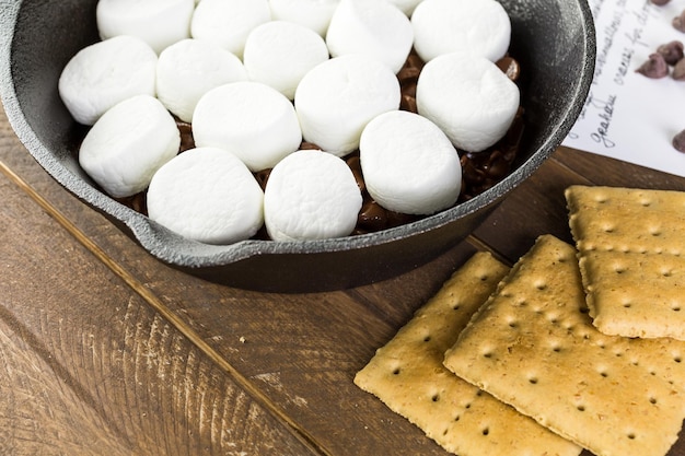 Preparazione smores tuffo preparato con grandi marshmallow in padella di ghisa.