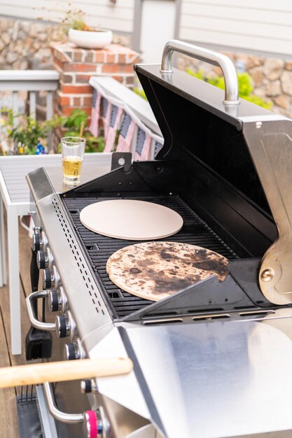 Preriscaldare le pietre per pizza su un grill a gas all'aperto.