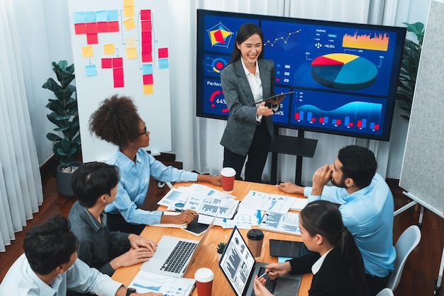 Presentazione aziendale vista dall'alto con dashboard di analisi dei dati sullo schermo TV nella moderna sala riunioni Uomini d'affari che fanno brainstorming o lavorano insieme per pianificare la strategia di marketing aziendale Concord