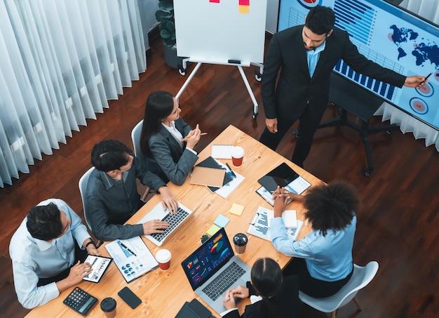 Presentazione aziendale vista dall'alto con dashboard di analisi dei dati sullo schermo TV nella moderna sala riunioni Uomini d'affari che fanno brainstorming o lavorano insieme per pianificare la strategia di marketing aziendale Concord