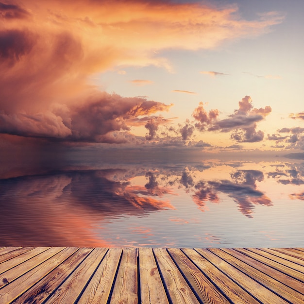 Presentazione del prodotto con sfondo del bellissimo tramonto sul mare con riflesso nell'acqua