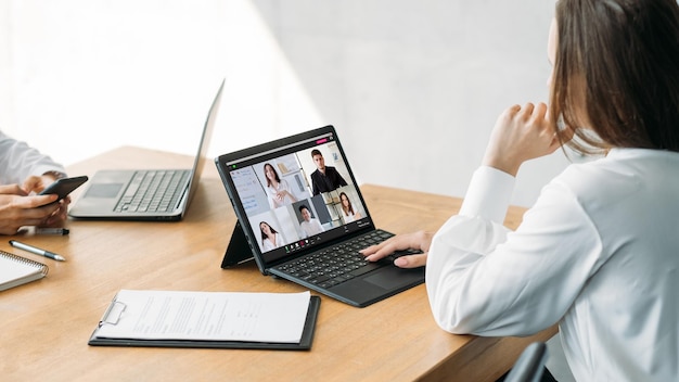 Presentazione video Conferenza Web di routine dell'ufficio Dipendente femminile che lavora online con un team aziendale professionale sullo schermo del laptop sul posto di lavoro