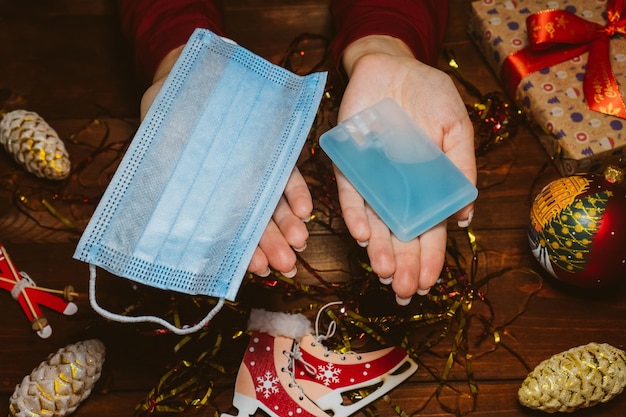 Presente in tempo di concetto di pandemia Vista dall'alto delle mani femminili con maschere per il viso e antisettico