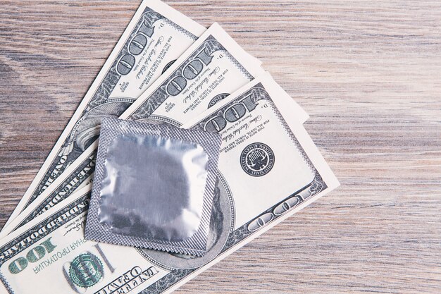 Preservativo sui soldi sul tavolo