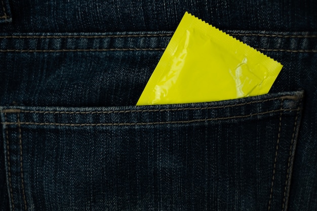 Preservativo sulla tasca dei jeans (concetto di Giornata mondiale contro l&#39;AIDS), soft focus.