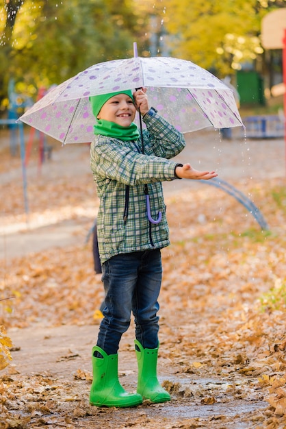 Preteen kid in cappello verde a piedi in autunno parco