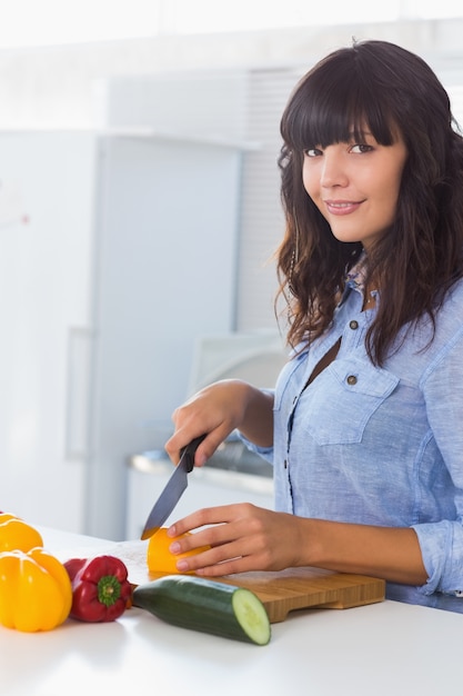 Pretty brunette chopping pepper