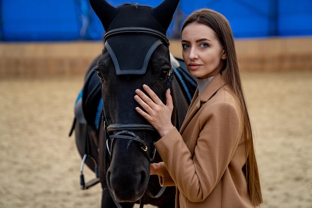 Pretty Woman in posa con il cavallo in campo Bella giovane donna con il cavallo