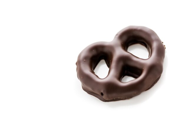 Pretzel ricoperto di cioccolato gourmet su sfondo bianco.