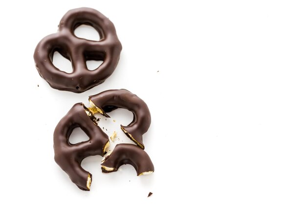 Pretzel ricoperto di cioccolato gourmet su sfondo bianco.