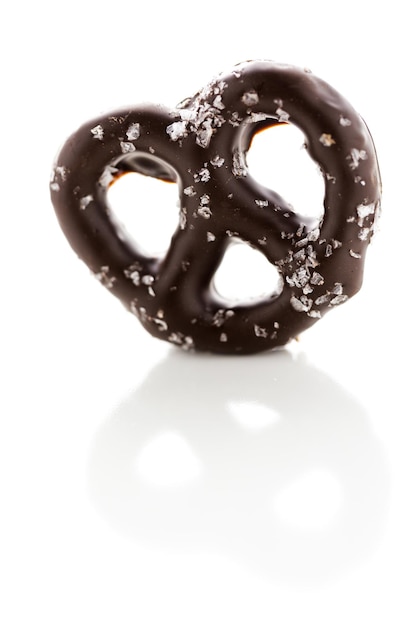 Pretzel ricoperto di cioccolato gourmet su sfondo bianco.