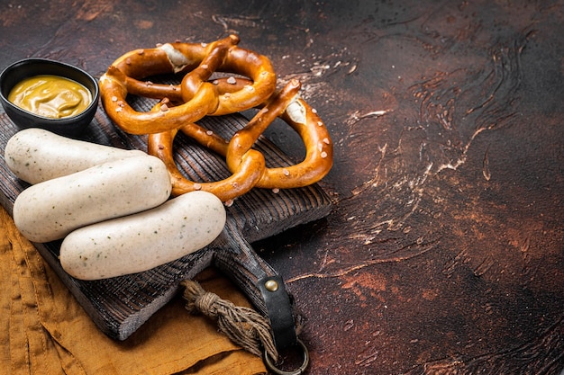 Pretzel tedesco tradizionale con salsiccia bianca e senape Sfondo scuro Vista dall'alto Spazio di copia