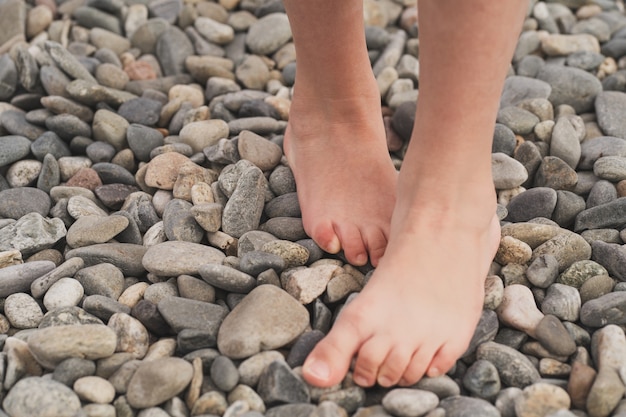 Prevenzione dei piedi piatti nei bambini il bambino cammina sui sassi a piedi nudi trattamento di va...