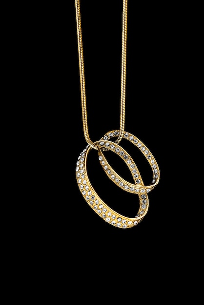 Prezioso ciondolo di diamanti appeso a una catena d'oro su sfondo nero