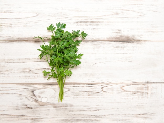 Prezzemolo su fondo di legno. Erbe biologiche fresche. Ingredienti alimentari sani