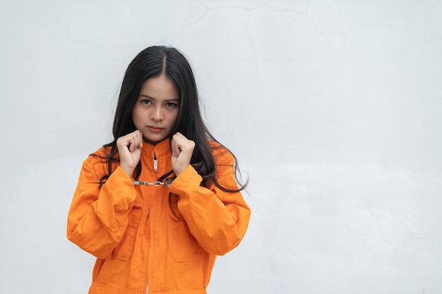 Prigioniero in abito arancione conceptRitratto di donna asiatica in uniforme della prigione su sfondo bianco