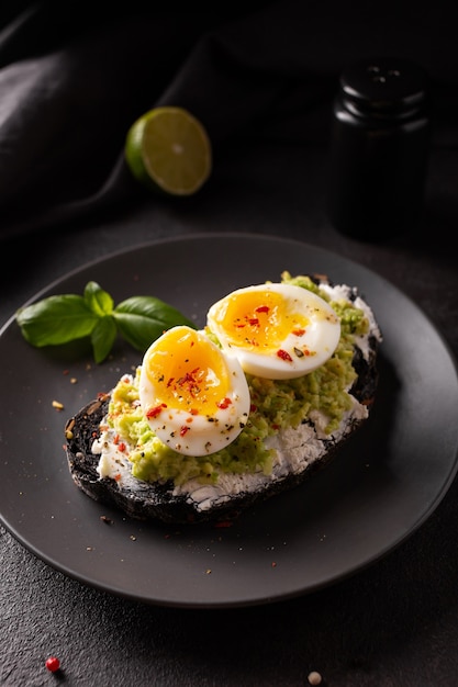 Prima colazione con pane tostato di avocado con uova su un piatto