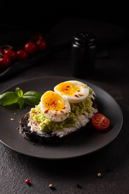 Prima colazione con pane tostato di avocado con uova su un piatto