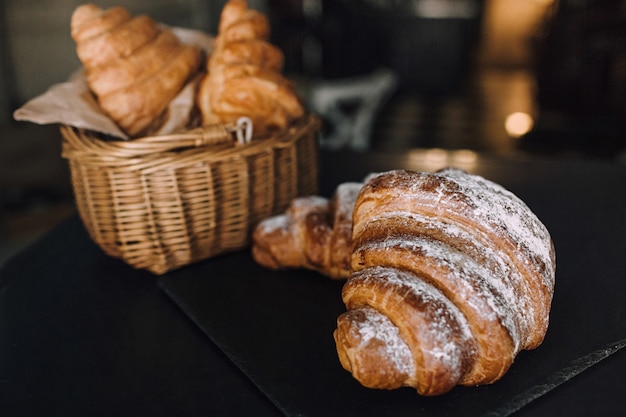 Prima colazione deliziosa con i croissant freschi su un fondo nero, spazio delizioso della copia di vista superiore di cottura per testo