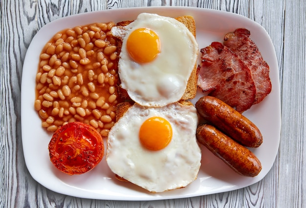 Prima colazione inglese con due fagioli di salsiccia di uova