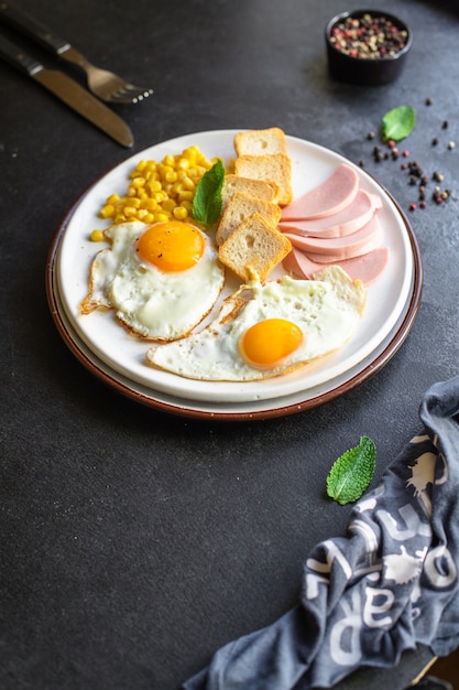 Prima colazione inglese uovo fritto pane tostato verdure mais formaggio e più pronto da mangiare sul tavolo