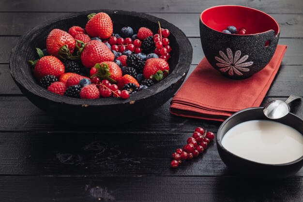 Prima colazione sana che mangia un mix di frutti di bosco crudi freschi