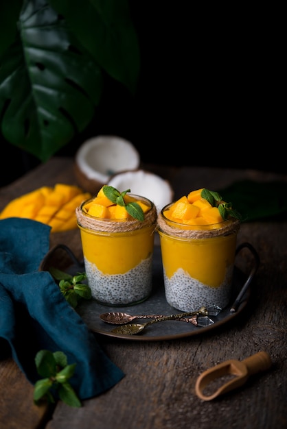 Prima colazione sana fatta in casa, budino di chia con latte di cocco e mango su un tavolo di legno